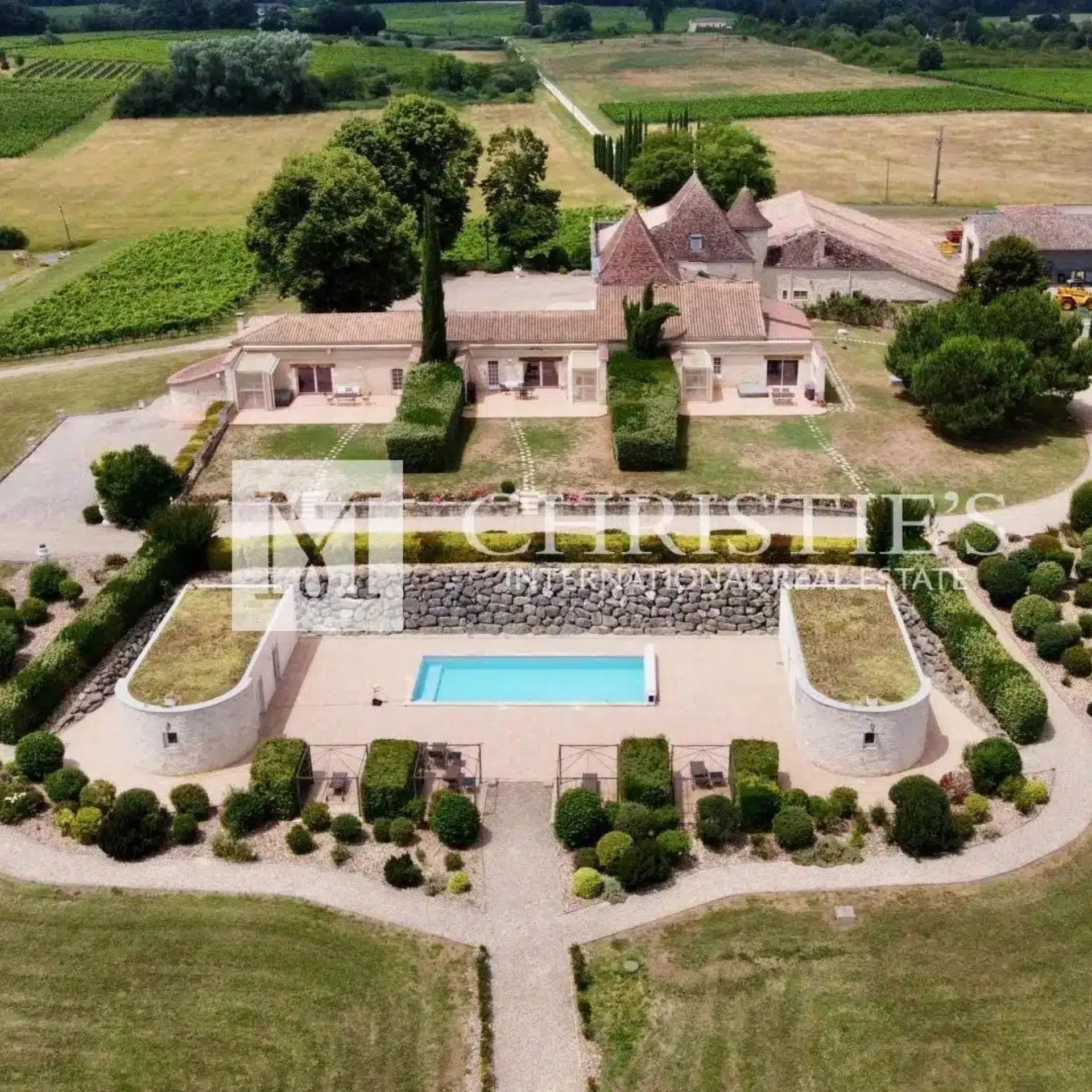 A view of a vineyard with pool and built property